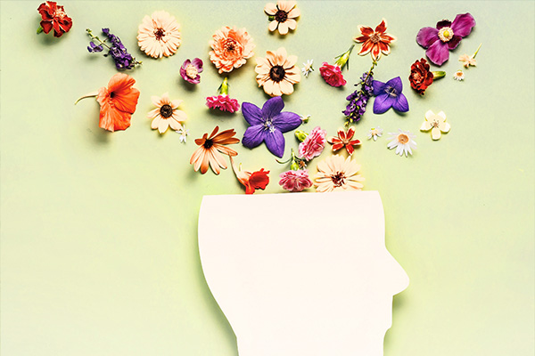 Graphic illustration of flowers coming out of the top of a head, seen in a rough silhouette.