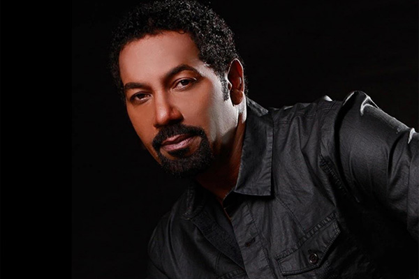 Headshot of a man with a goatee wearing a gray shirt.