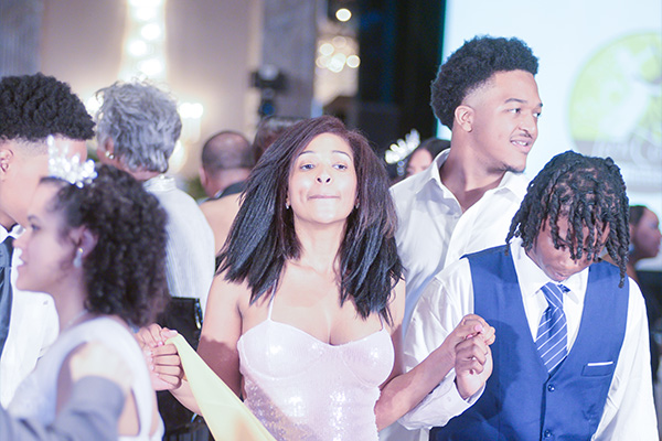 Teens in formalwear dancing and hanging out.